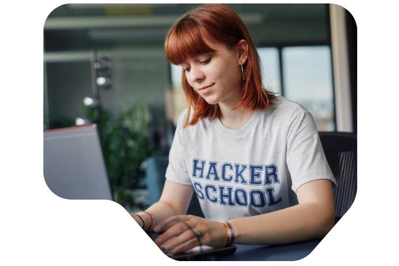 Mädchen sitzt am Computer und programmiert